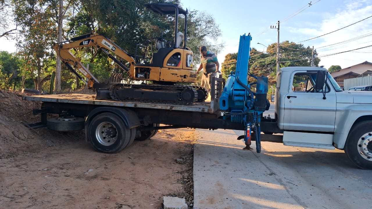 Mini escavadeira sendo transportada em caminhão prancha